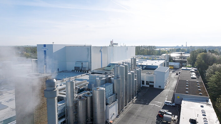 Luftaufnahme des Lactalis-Industriekomplexes mit Fabrikgebäuden, großen Silotanks und Werksgelände.