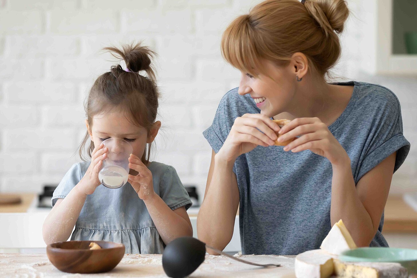Mutter mit Tochter, welche Milch trinkt